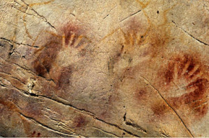 This undated photo shows a detail of the 'Panel of Hands' in El Castillo Cave, Spain, showing red disks and hand stencils made by blowing or spitting paint onto the wall. A date from a disk shows the painting to be older than 40,800 years, making it the oldest known cave art in Europe. Pedro Saura/AAAS/AP